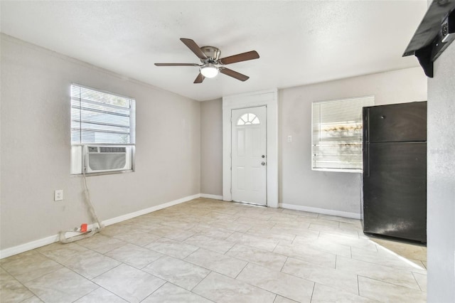 entryway featuring a textured ceiling, a wealth of natural light, cooling unit, and ceiling fan