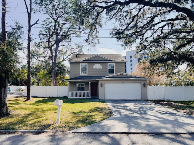 view of property featuring a garage, a front yard, and covered porch