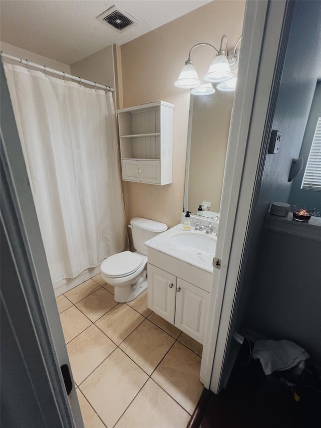 bathroom with vanity, a textured ceiling, tile patterned floors, and toilet