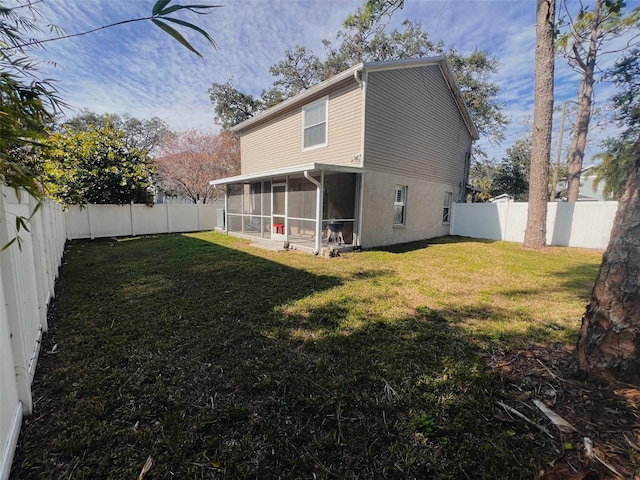 back of house with a sunroom and a lawn