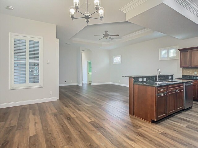 kitchen featuring sink, a raised ceiling, dark hardwood / wood-style flooring, ceiling fan with notable chandelier, and ornamental molding