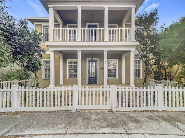 10130 Balcony St, New Port Richey, FL 34655 - view of front of property with a balcony, a porch, stucco siding, and a fenced front yard