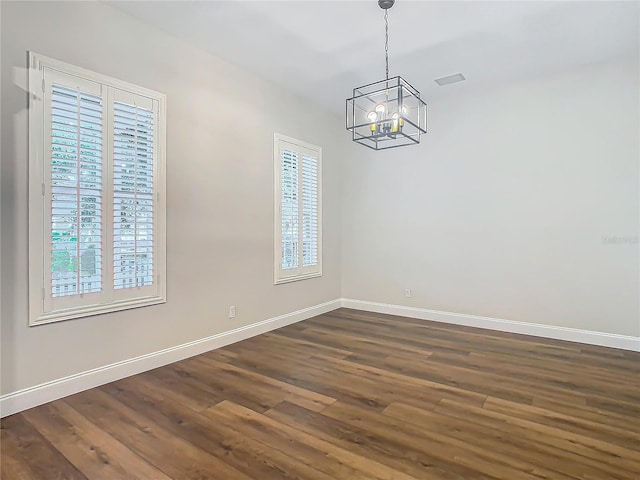 unfurnished dining area featuring plenty of natural light, a chandelier, and dark hardwood / wood-style floors