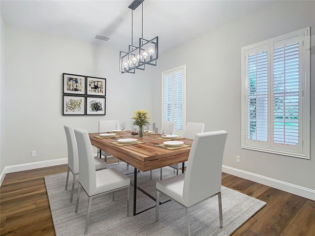 dining room featuring a chandelier and dark wood-type flooring