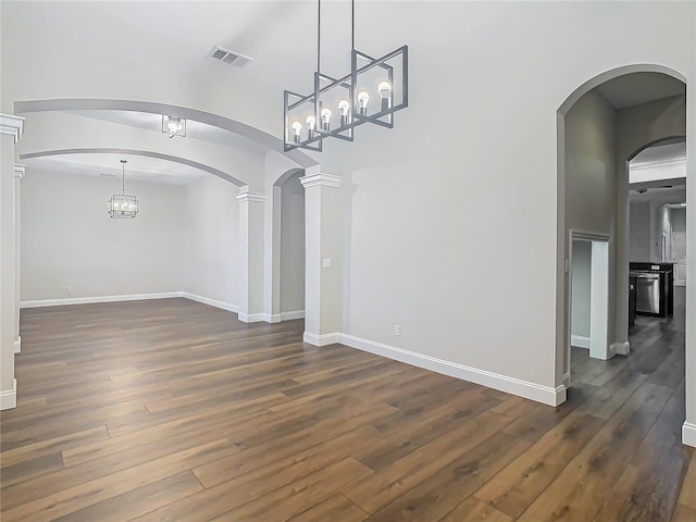 unfurnished dining area with dark hardwood / wood-style floors and decorative columns