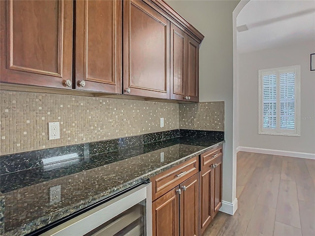 kitchen with dark stone counters, wine cooler, decorative backsplash, and light hardwood / wood-style floors