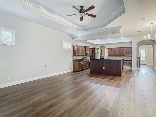 kitchen with a tray ceiling, crown molding, dark hardwood / wood-style flooring, and range