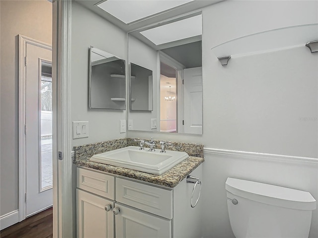 bathroom with vanity, toilet, and wood-type flooring