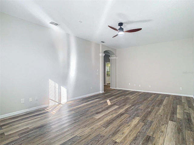 10130 Balcony St, New Port Richey, FL 34655 - unfurnished room with a ceiling fan, dark wood finished floors, ornate columns, and arched walkways