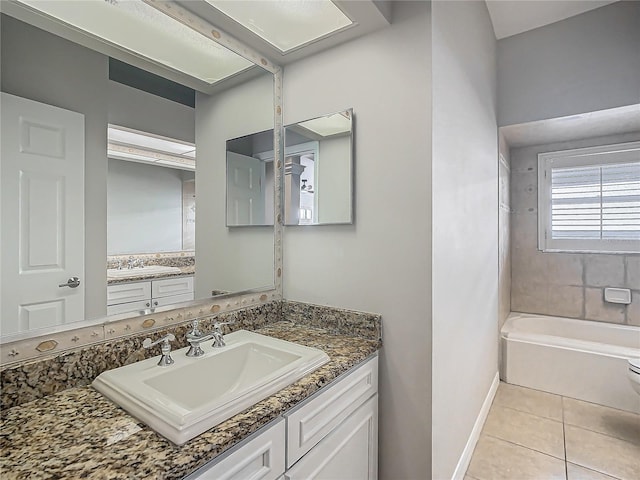 bathroom featuring toilet, vanity, tile patterned floors, and a bathtub