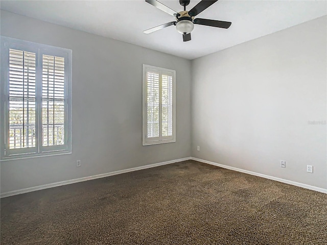 carpeted empty room with ceiling fan and a wealth of natural light