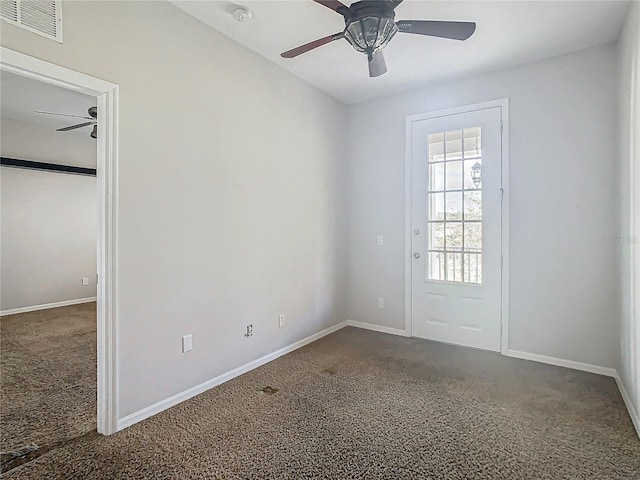 unfurnished room with ceiling fan and dark carpet