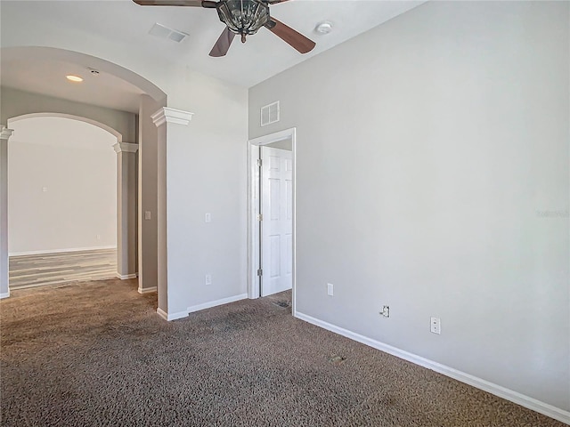 carpeted spare room featuring ceiling fan and decorative columns