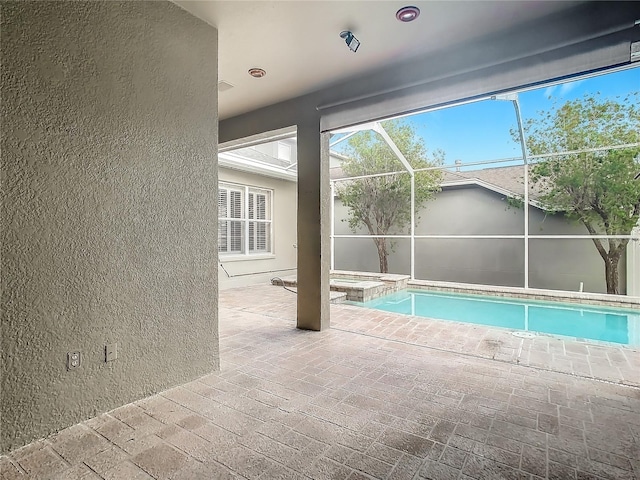 view of swimming pool featuring a lanai, an in ground hot tub, and a patio