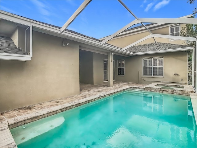 back of house featuring a lanai, a swimming pool with hot tub, and a patio area