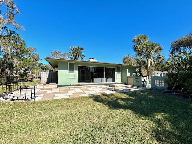 rear view of house featuring a yard and a patio area