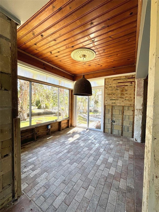 unfurnished sunroom with wooden ceiling