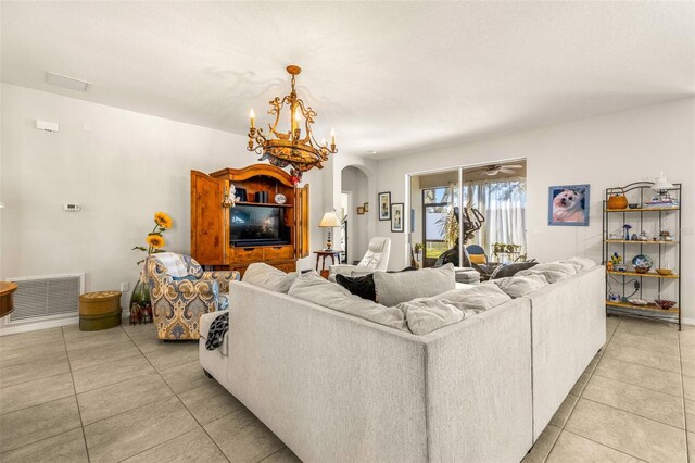 living room with light tile patterned floors and an inviting chandelier