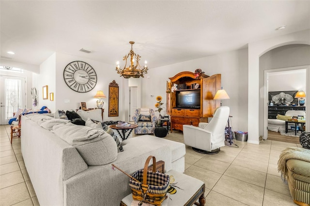 living room with light tile patterned floors and an inviting chandelier