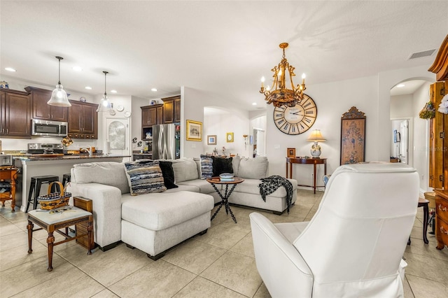 living room with light tile patterned floors and an inviting chandelier