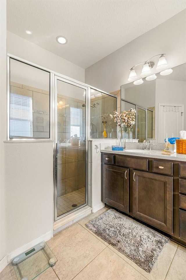 bathroom featuring tile patterned flooring, vanity, and a shower with door