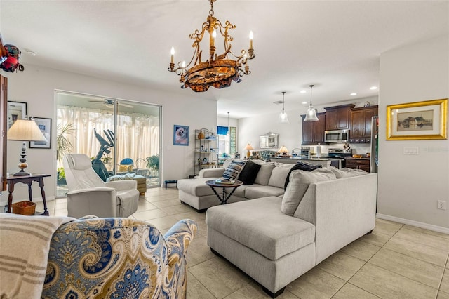 living room featuring light tile patterned flooring, a healthy amount of sunlight, and ceiling fan with notable chandelier