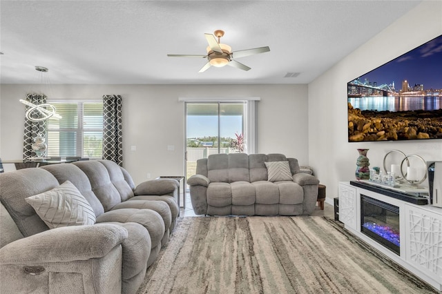 living room with ceiling fan and a textured ceiling