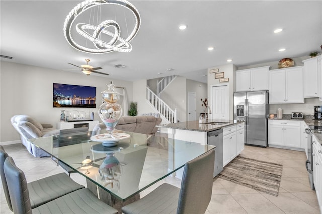 dining space with sink, light tile patterned floors, and ceiling fan