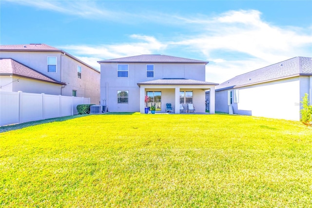 back of property featuring cooling unit, a lawn, and a patio area