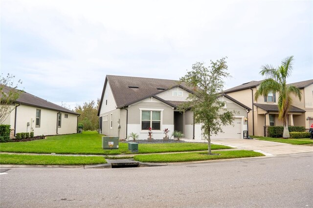 view of front of home with a front lawn, central AC unit, and a garage