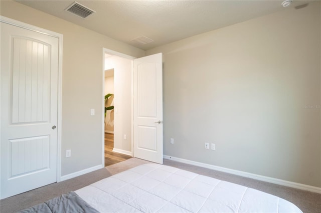 bedroom featuring light colored carpet and a textured ceiling