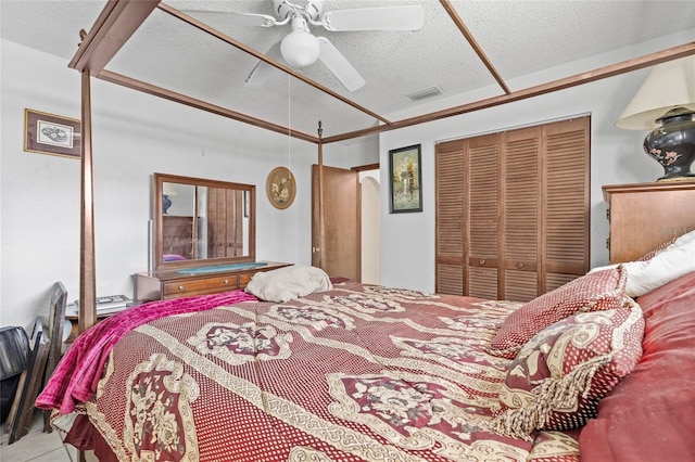 bedroom featuring ceiling fan, a closet, and a textured ceiling