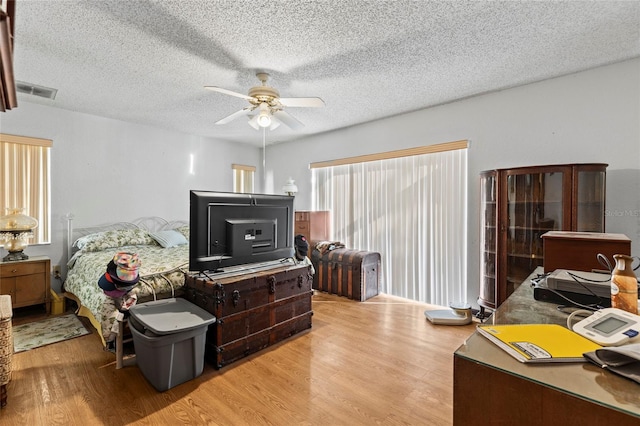 interior space with ceiling fan, a textured ceiling, and light hardwood / wood-style flooring