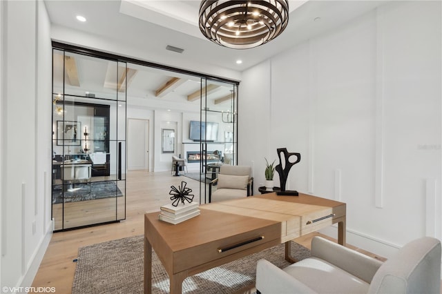 office space with beam ceiling, light hardwood / wood-style flooring, and a chandelier