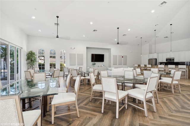 dining room featuring parquet floors and a high ceiling