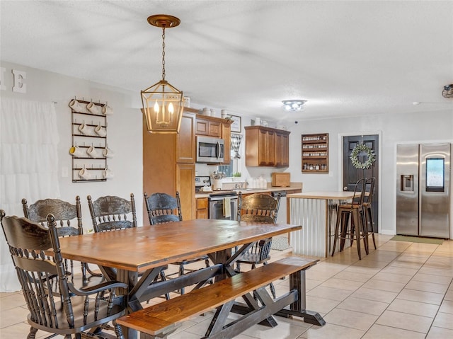 tiled dining room featuring a textured ceiling and a notable chandelier