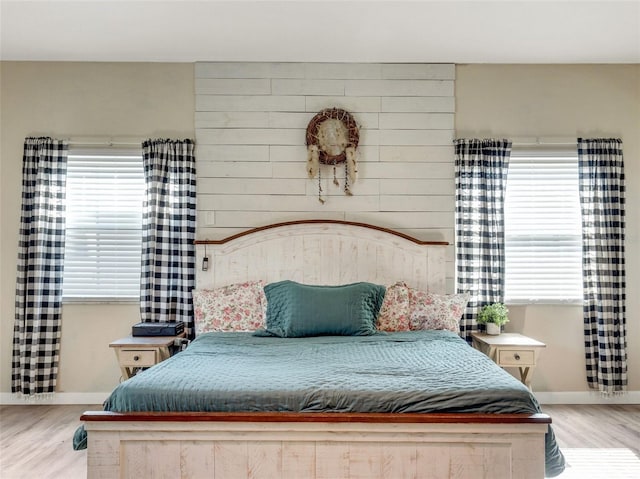 bedroom with light hardwood / wood-style floors and multiple windows