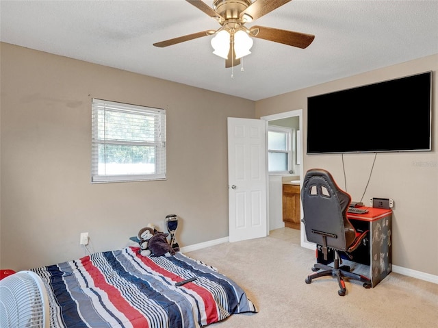 bedroom with light carpet, a ceiling fan, baseboards, and a textured ceiling