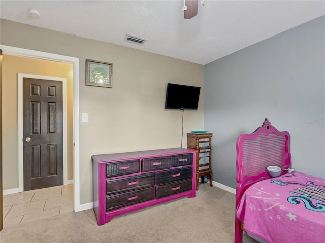 carpeted bedroom featuring ceiling fan, tile patterned flooring, visible vents, and baseboards