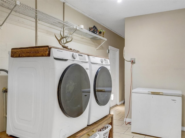 laundry area with laundry area, separate washer and dryer, and light tile patterned flooring