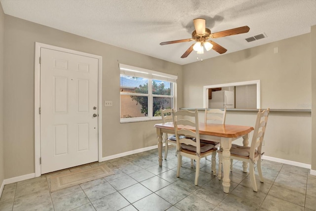 dining area with light tile patterned floors, a textured ceiling, and ceiling fan