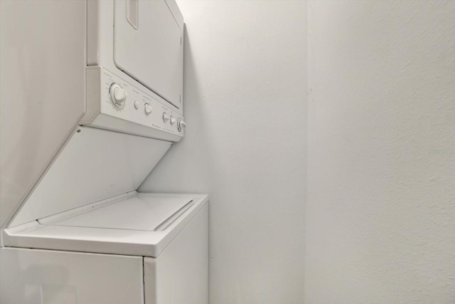 washroom featuring stacked washer and clothes dryer