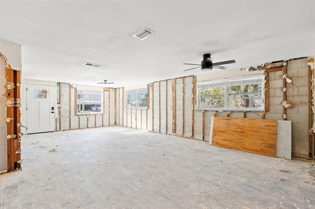 interior space featuring a textured ceiling, ceiling fan, and a healthy amount of sunlight