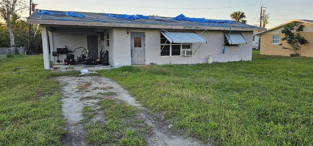 back of house with cooling unit and a lawn