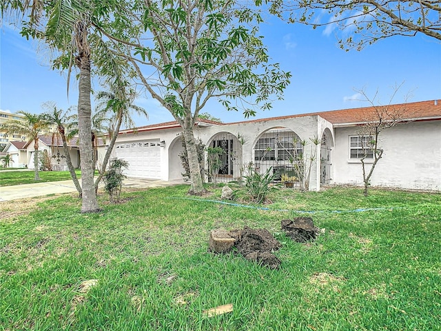 ranch-style house featuring a front yard and a garage