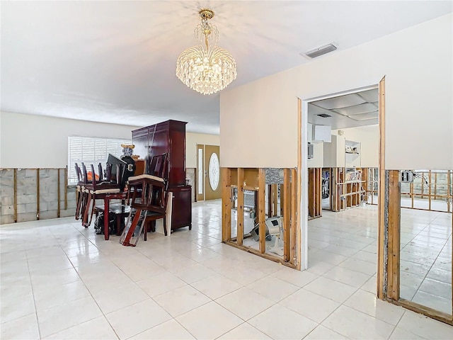 dining area featuring light tile patterned floors and an inviting chandelier