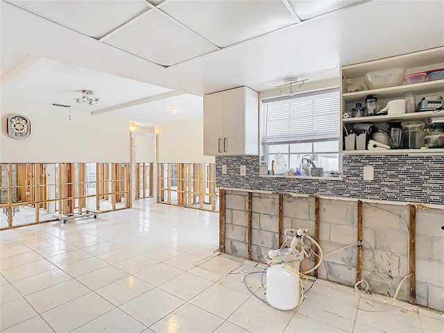 kitchen with decorative backsplash, light tile patterned floors, and white cabinetry