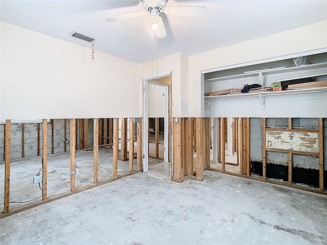 misc room featuring ceiling fan and concrete flooring