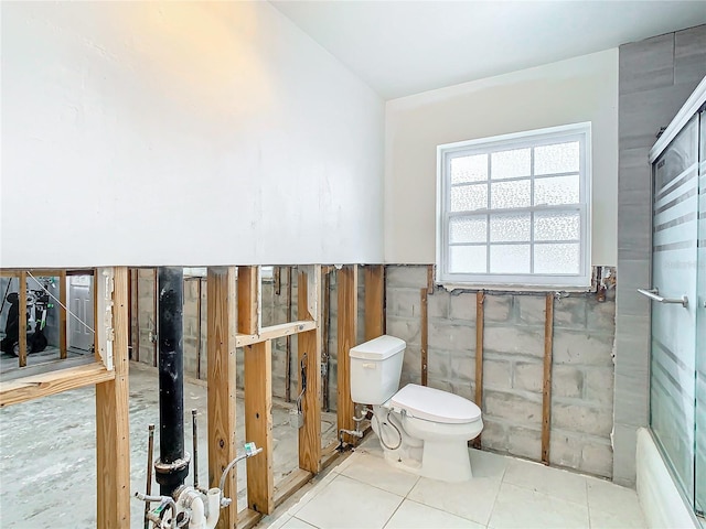 bathroom featuring tile patterned floors, toilet, and walk in shower