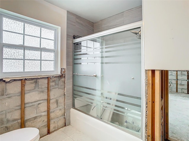 bathroom featuring shower / bath combination with glass door and toilet